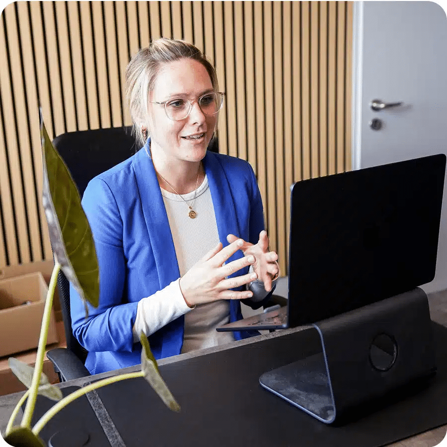 Invest4Kids Beraterin erklärt Eltern Finanzstrategie im Gespräch vor Laptop